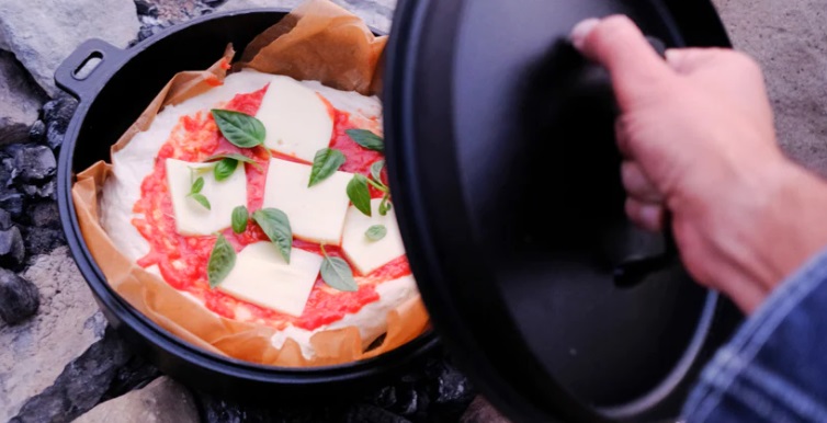 Dutch oven pizza is great alternative to takeout pizza you eat in front of the TV on a lazy Friday night-in. So why not go one better when you’re camping by making homemade Dutch oven pizza at the campfire. 

Depending on the number of people you’re cooking for, you can share the pizzas between a few people, as they’re usually bigger than your usual take-out pizza and the crust can be made thicker than usual as well.  

Basic Dutch oven pizza recipe 

To make this meal as easy as possible, use ready-made pizza dough, which you can just buy in the supermarket. Although, I will give a homemade pizza dough recipe below if you want to bring this recipe up a notch! 

Start by heating some coals on your campfire. Then spray your Dutch oven with cooking spray, or line with baking paper, to make sure the pizza doesn’t stick to the inside.   

Roll out the pizza dough and press it to the bottom of the Dutch oven, making sure to leave a lip around the edge for the crust. Then place some tomato sauce onto the dough. You can use ready-made pizza sauce, passata or you could even make your own pizza sauce in advance and bring it with you- I also give a recipe for that below.   

Then sprinkle some grated cheddar or mozzarella (or a mixture of both) onto the pizza. You can even use or sliced cheese if you've packed that for making cheese burgers.

Finally top with some olives, peperoni and any toppings you’d like. Or just leave plain for the children and you can then add toppings before you serve. 

Then set aside around 15 coals from the ones you heated up previously and place a lid on your Dutch oven. 

Put the oven on top of the coals and then put the extra 15 coals on top of the Dutch oven.  

Leave for 25 minutes and then check whether the pizza is cooked- the crust should be crispy, and the cheese should have melted. 

You can then leave the pizza for another 5/10 minutes depending on how you like it, just remember that the cooking time can vary depending on the temperature of your coals and the size of the Dutch oven. 

Finally take the pizza out of the Dutch oven carefully, and enjoy!

Topping ideas 

There is an almost endless variety of different pizza topping options you could try. 

Everyone has their favourite pizza toppings, but if you’d like to mix things up, here is some inspiration.   

You could replace the classic tomato sauce with some fresh pesto, then top with sliced mushrooms, parmesan, a handful of halved cherry tomatoes, and some ham (you can omit this if you want to keep it veggie). Then, once it’s finished cooking, you can add a handful of rocket.   

You could also top the pizza with tomato sauce, caramelised onions, feta and some spinach. 

Or for another unusual pizza you could serve the pizza with some kale and chopped sausage on top, this is a great way to use up any leftovers.  

To make a vegetable pizza, top with some sliced red peppers, courgette pieces, artichoke, asparagus, and spinach (or any selection of these veggies). 

You could also add some spinach onto a margherita and break an egg into the middle for a Fiorentina-style pizza.   

One of the most basic (but controversial) pizza toppings is ham and pineapple. If you’re a fan of this infamous topping combination, then bring some tinned pineapples with you and add them to the top of the pizza with some pieces of ham. 

There is an endless variety of pizza topping options to try so get imaginative- you could even let kids make their own pizzas for a fun activity. A great way to get them engaging with the cooking.

Dutch oven cooking ideas 

If you enjoyed cooking these pizzas in your Dutch oven and would like some more super simple recipes to make in a Dutch oven over the campfire, then be sure to check out To Stew or not to Stew. 

If you’d like another cheesy, tomatoey and unbelievably delicious camping recipe then also definitely have read of the  Camping Staple(CSC) you can count on the ever-popular lasagne recipe you can make using your Dutch oven.  

How to make your own pizza dough 

If you have a bit more time in advance, why not try out making your own pizza dough- it’s actually really easy. 

Mix 400g flour, a 7g sachet of fast action dried yeast, 1 tsp fine sea salt and 1 tsp sugar together in a large self seal ziplock bag (or a large soup freezer bag with a clip). Then make a well in the centre and add 2 tbsp olive oil then around 225ml water to make the mixture into a doughy consistency. 

Knead this in the bag for a minute until it becomes smooth.   Put this to one side for the dough to rest whilst you prepare the pizza toping (grating cheese, cutting veggies etc.). To shape the pizzas, roll one ball at a time on a lightly floured surface until they are around 25cm in diameter. The crust of the pizza should be around 1cm thick, and the centre should be 0.5cm thick. 

You can make this in a bag the day before and store in the fridge to pack with your other food when you go camping. How easy is that.

Then add toppings and allow the pizza to rest for around 10-15 minutes until it has risen a little.

Stuffed crust 

If you’re putting mozzarella on top of your pizza, then why not make a super luxurious stuffed crust pizza with any cheese you have left over. 

Just use around 125g mozzarella to create a ring around the crust of your pizza in the Dutch oven, making sure you leave a gap of around 0.5cm between the mozzarella and the edge of the pizza. 

Then brush a bit of water on the mozzarella ring and fold around the outside layer to create the stuffed crust, pressing firmly to stick the dough in place.

Making your own sauce 

You could also make your own pizza sauce at home and bring it with you camping, or even make it on your camping stove. 

Heat a bit of oil in a pan and add one small finely chopped onion and some salt to the pan. 

Then fry gently until the onion is soft and translucent. 

Add 1-2 crushed garlic cloves and fry for a minute.   

Then add two 400g cans chopped tomatoes (though I prefer passata), 3 tbsp tomato puree and a bay leaf, 2 tsp brown sugar. 

Bring to the boil, then lower the heat and allow to simmer for around 30 minutes. 

You can leave the sauce as is, or blend if you like your pasta sauce a bit smoother. 

Finally stir in some chopped basil. 

This pasta sauce keeps for about one week in the fridge or can be stored in the freezer until you go camping.